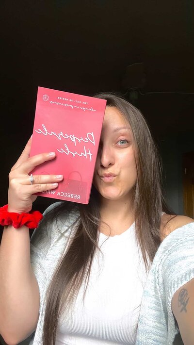 Woman posing for camera holding copy of Feels Like Coming Home by Rebecca Wrights
