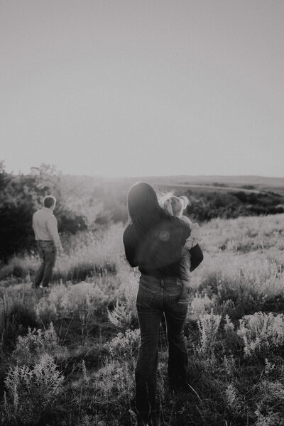 family walking in a field together mom holding daughter