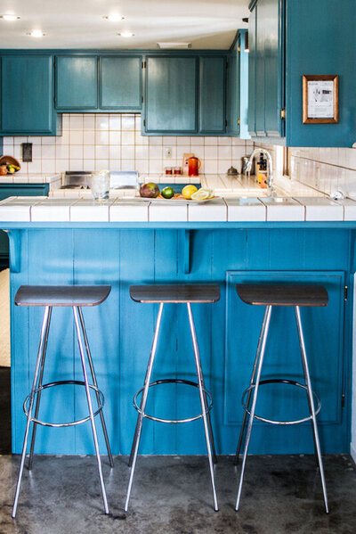 Place branding image Gatos Trail Ranch kitchen three stools in front of blue counter