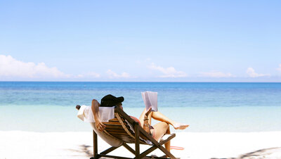 Woman sitting down on her chair facing the ocean