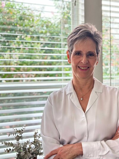 A Dallas financial planning and analysis expert, dressed in a white shirt, known for her strong critical and analytical skills. The image showcases her professionalism and expertise in financial consulting.