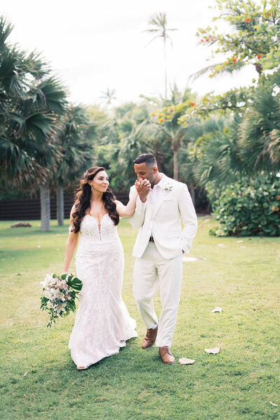 Bride and groom walking hand in hand through Isabela, Puerto Rico

