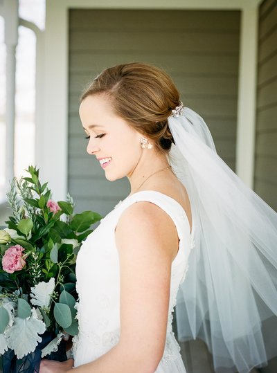 Photo  of an unveiled Bride in her wedding dress holding a bouquet
