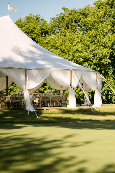 Wedding reception table with patterned green table cloth, and green accent vases