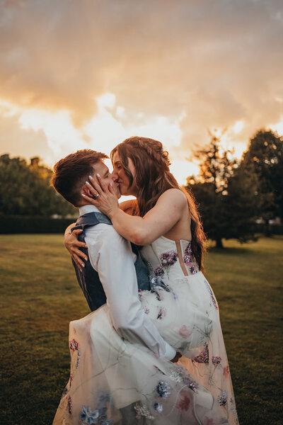 newlywed couple kiss in sunlight