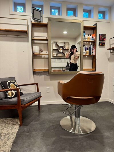 Hair extensions expert, Arianna, is seen in the reflection of a mirror in her luxury, private hair salon in Eugene, Oregon.