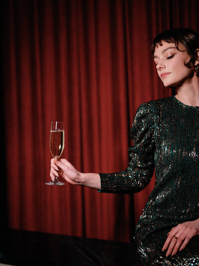 Female model holding champagne glass for commercial photography at Riggs Hotel