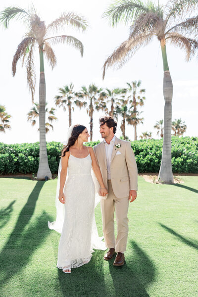 bride and groom walking and holding hands by wedding photographers in miami fl