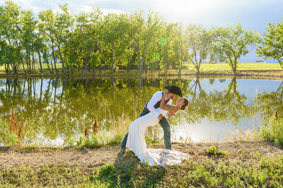 Western-themed same-sex couple sharing a golden hour kiss at Spruce Mountain Ranch, captured by Colorado micro-wedding photographer with a romantic and inclusive style