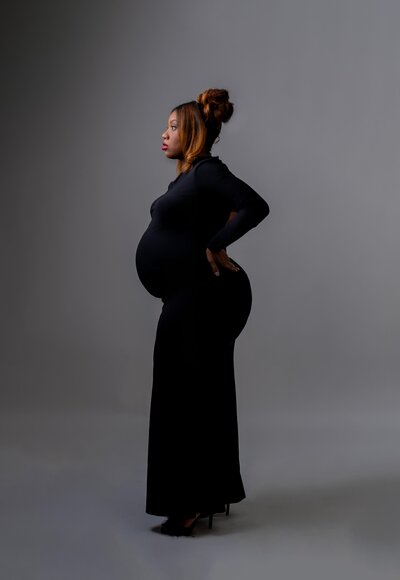 Maryland Maternity Photographer- Snapzbytie Photography - Mom side profile of baby bump wearing all back dress and heels