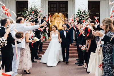 The bride and groom second lining in the French Quarter. Dancing in the streets with umbrellas and the jazz band.  Photographed by Casey McMurray Photography