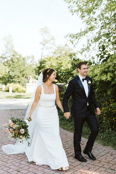 bride and groom walking together in lake park after their wedding ceremony at north point light house in milwaukee wiscosnin