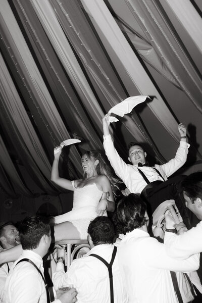 A wedding couple at their ceremony space touching temples and smiling softly 