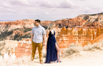 bride and groom sitting on rocks with Lake superior in the background and tall, green, pine trees
