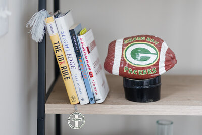 Book shelf holding 4 books and a football