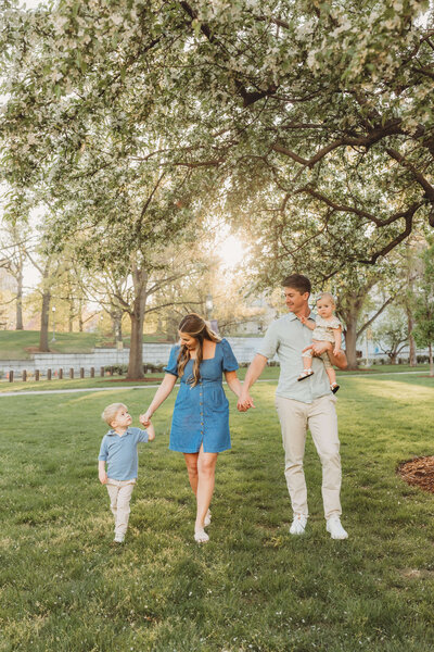 family of four walking together as the sun sets behind them 