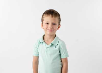 A blonde boy smiling happily in his school picture.