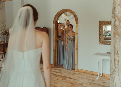 bridesmaids first look through doorway at Sinclair of Skaneateles
