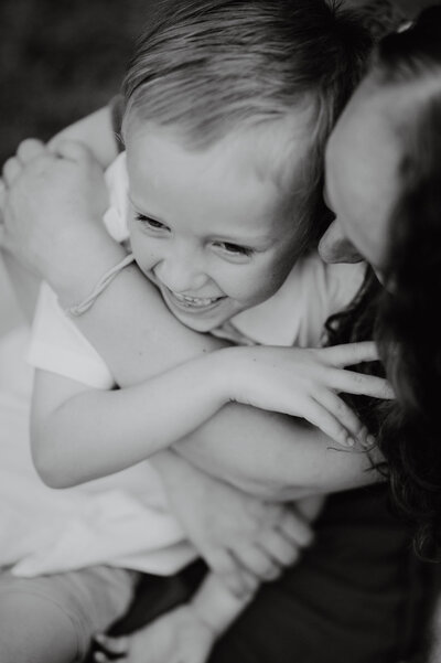 Young boy being cuddled by his mama