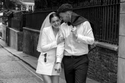 Newly wed bride and groom walking in the city after their intimate London wedding