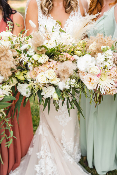 bride holding bouquet of pink and ivory flowers