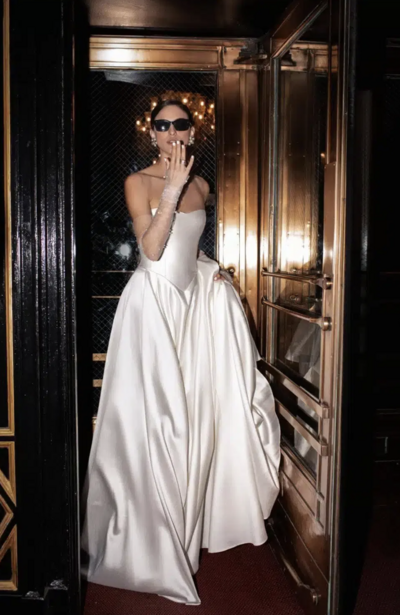 black and white image bride wearing strapless satin wedding dress with long train