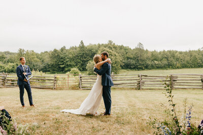 bride and groom embrace and kiss at the end of their ceremony