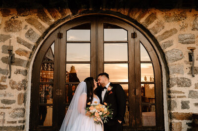 Bride and groom smiling at their loved ones during their cake cutting - by wedding photographer Daniella Diaz Photo