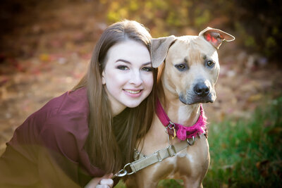 Senior portrait of a girl kneeling down & hugging her dog, posing for a South Shore, MA portrait photographer