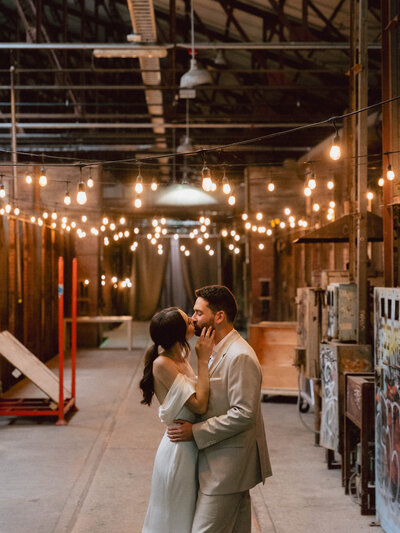 Brid e and Groom Kiss Under Chuppah at Evergreen Brickworks