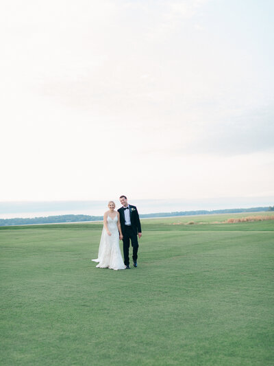 Bride and Groom walking on golf course at Belfair 1811 wedding