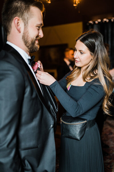 Austin wedding planners Bianca Nichole and Co adjusting groom's boutonniere 