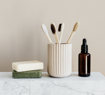 photo of toothbrush cup, amber bottle, and bars of soap, styled properly