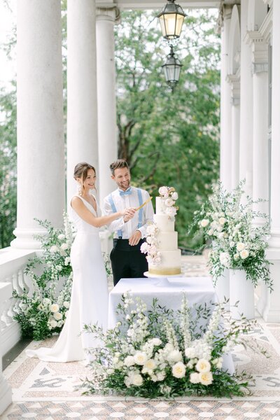 Luxury wedding couple cutting their wedding cake outdoors at the palace Coburg 