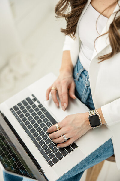 Laura Tjepkes Photography typing out a message on her computer.