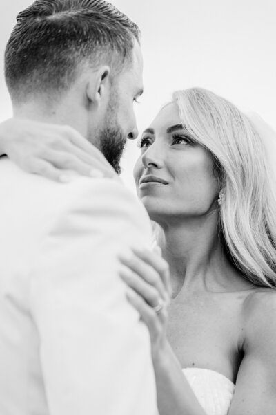 A black and white close-up of a bride gazing lovingly at her groom during their wedding at Spring Island, SC. Captured in a timeless and elegant style, this emotional moment reflects deep love and connection on their special day.