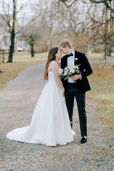 Bride and groom gazing into each others eyes in autumn landscape