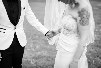 Elopement wedding couple holding hands in black and white photo.
