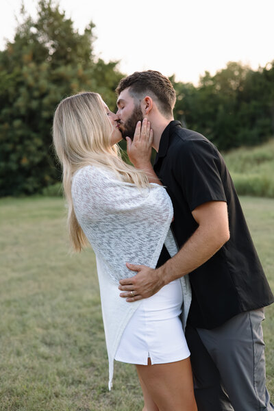 Girl sitting on fiance while grabbing his neck looking into eyes