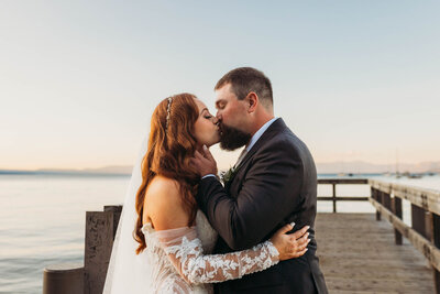 bride and groom kissing on a dock