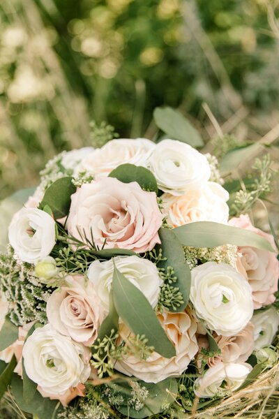 close up of wedding rings on wedding flowers