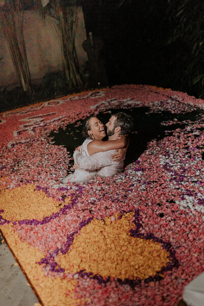 bride and groom embracing in water