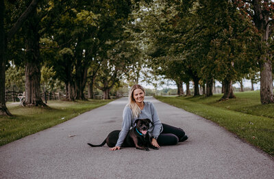 girl sits on road with dog