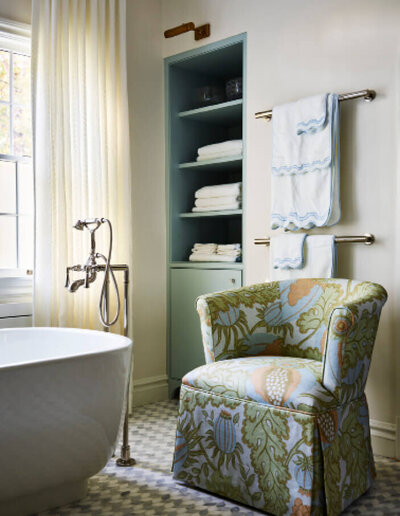Interior designer in Boston completed a luxury bathroom design with modern fixtures and a custom upholstered slipper chair in Christopher Farr cloth, part of a Milton renovation.