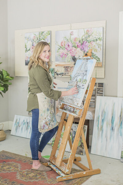 Miriam standing at her easel painting