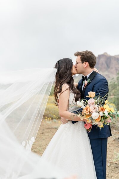 Bride and Groom kissing with wind catching veil The Paseo Wedding Venue