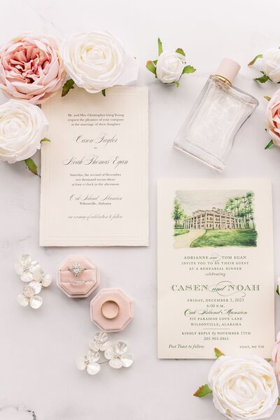 Wedding flatlay with wedding invitations and engagement rings