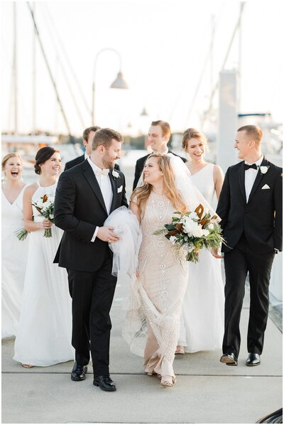 Bride and groom with their bridal party, walk along a dock in coastal Virginia.