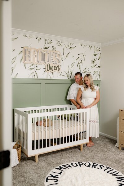 In Your Home Lifestyle Newborn Session with a couple and their newborn laying in his crib in a natural colored nursery