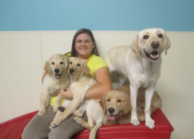 Puptown Charlotte staff and 4 golden dogs smiling a the camera.